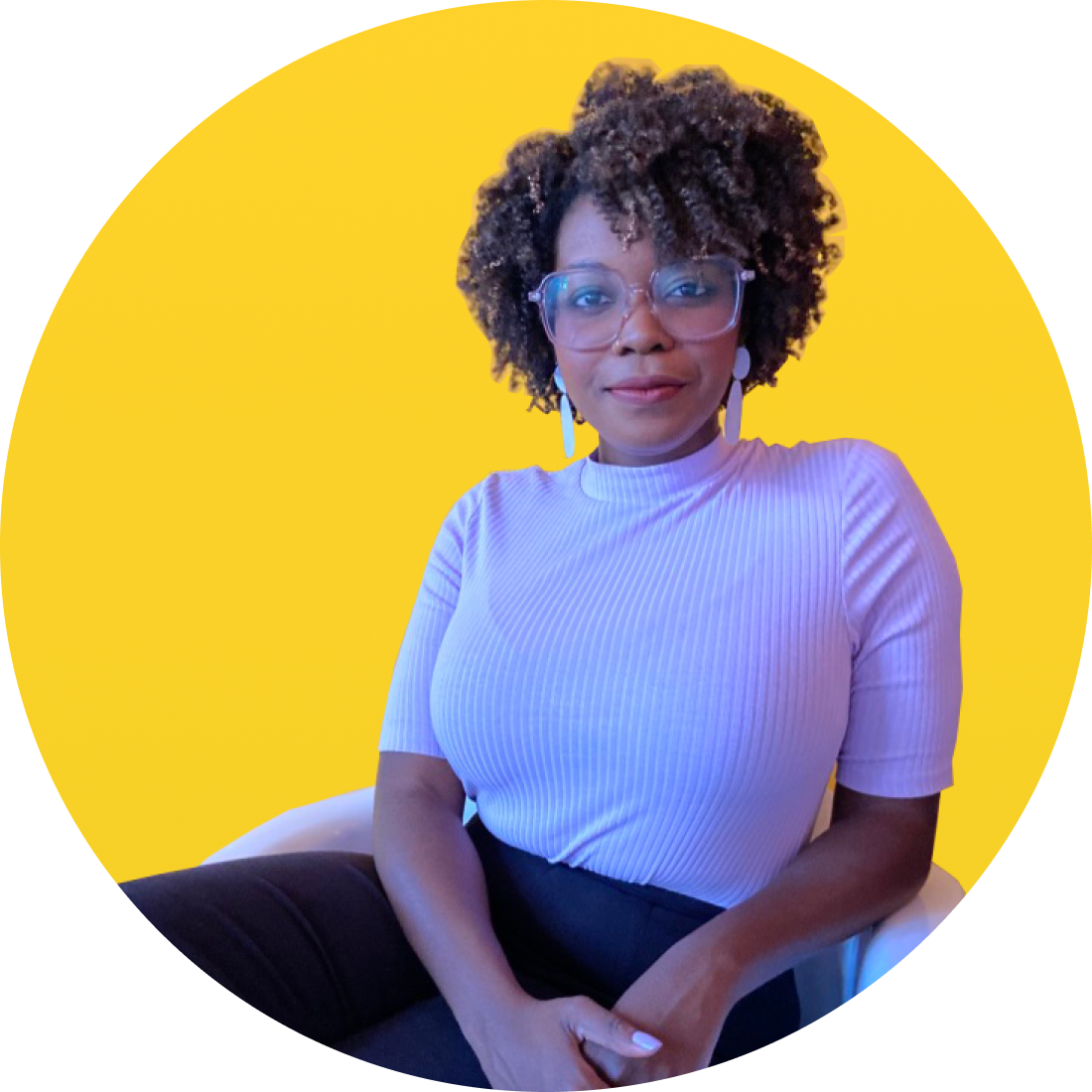 Dr. Seyi Amosu sitting in chair with her hands resting in her lap. She is against a bright yellow background.